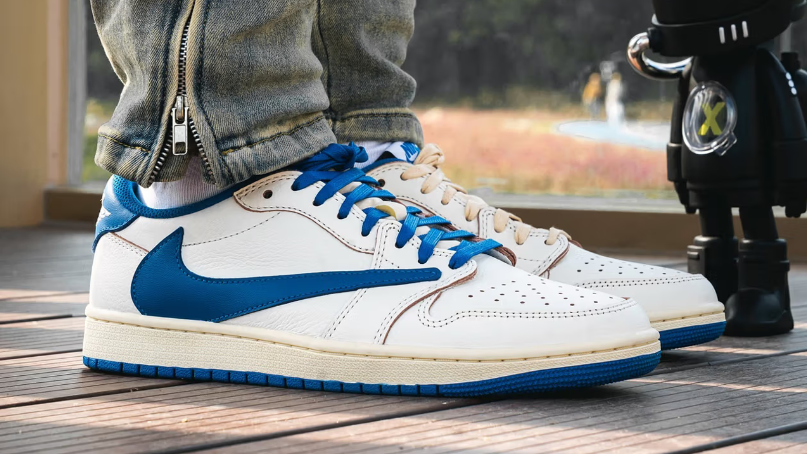 Hinh anh 3: Travis Scott x Fragment x Air Jordan 1 Low OG voi logo Swoosh nguoc va mau xanh Military Blue tren nen da trang.