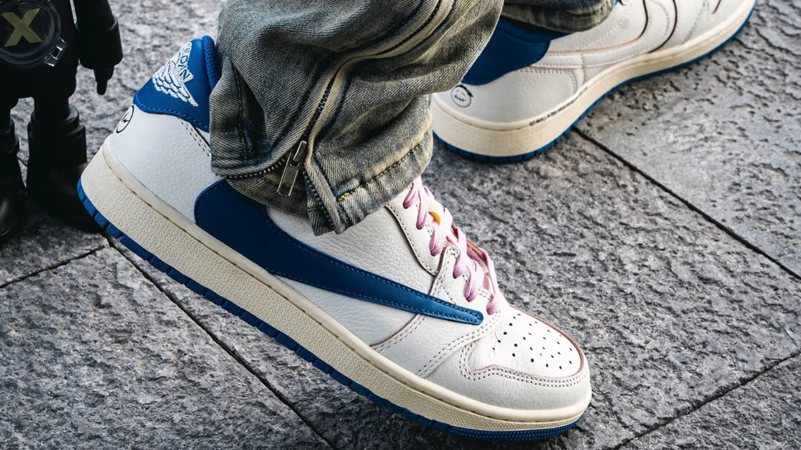 Hinh anh 4: Travis Scott x Fragment x Air Jordan 1 Low OG voi logo Swoosh nguoc va mau xanh Military Blue tren nen da trang.