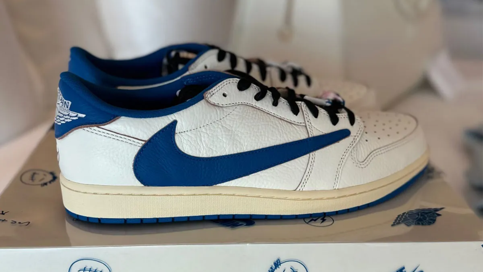 Hinh anh 5: Travis Scott x Fragment x Air Jordan 1 Low OG voi logo Swoosh nguoc va mau xanh Military Blue tren nen da trang.