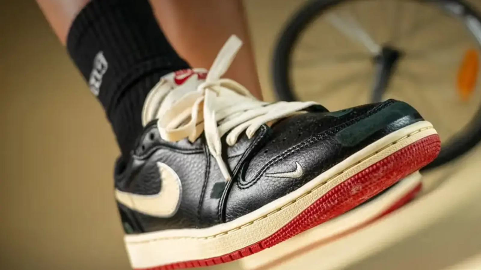 Hinh anh 2: Air Jordan 1 Low OG “Nitro” voi phoi mau Black/Muslin/Varsity Red, thiet ke boi Nigel Sylvester, bieu tuong thoi trang biker mua thu 2025.