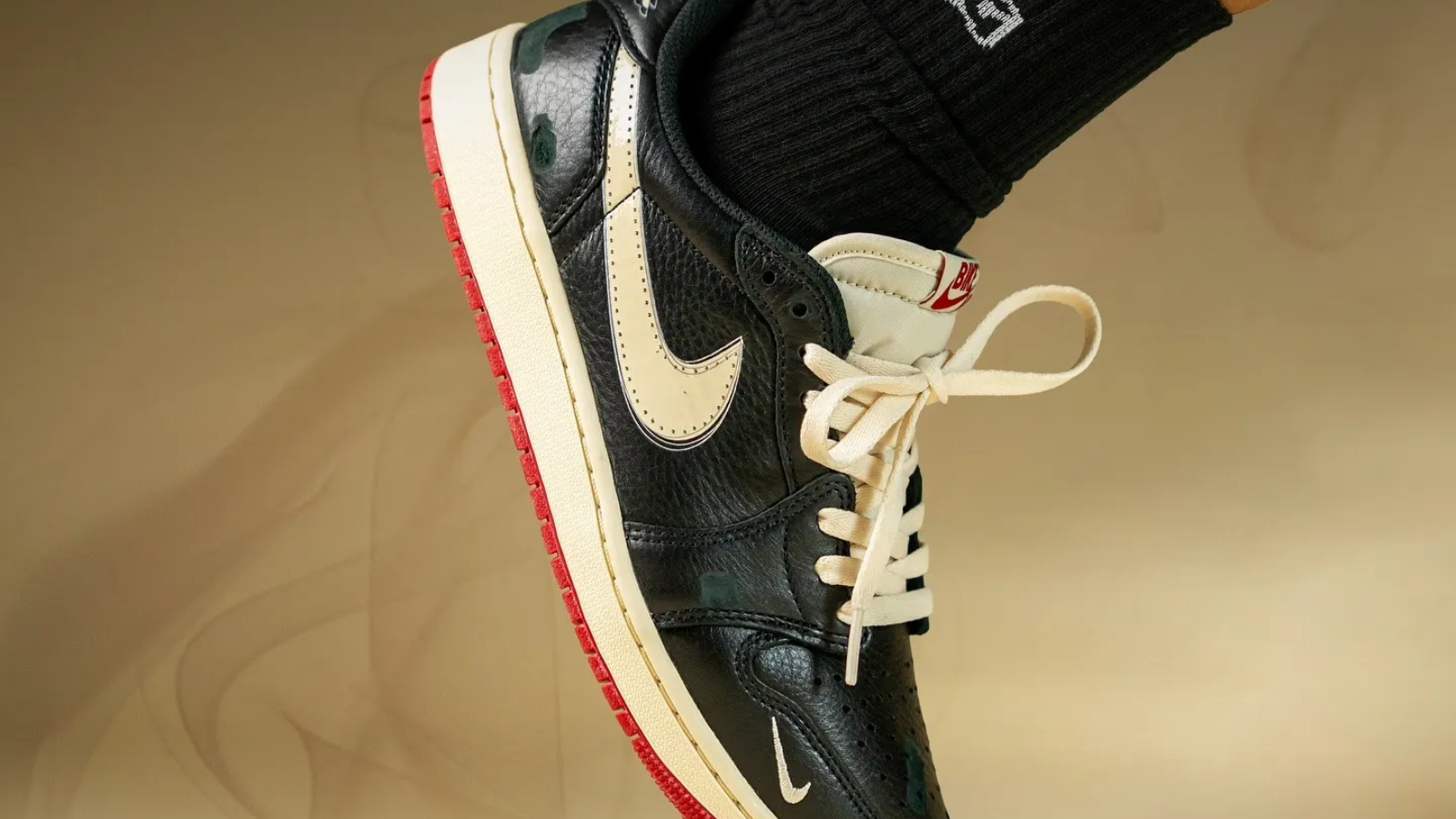 Hinh anh 4: Air Jordan 1 Low OG “Nitro” voi phoi mau Black/Muslin/Varsity Red, thiet ke boi Nigel Sylvester, bieu tuong thoi trang biker mua thu 2025.